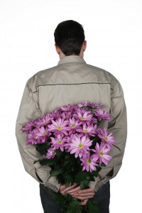 guy holding flowers behind his back surprise her
